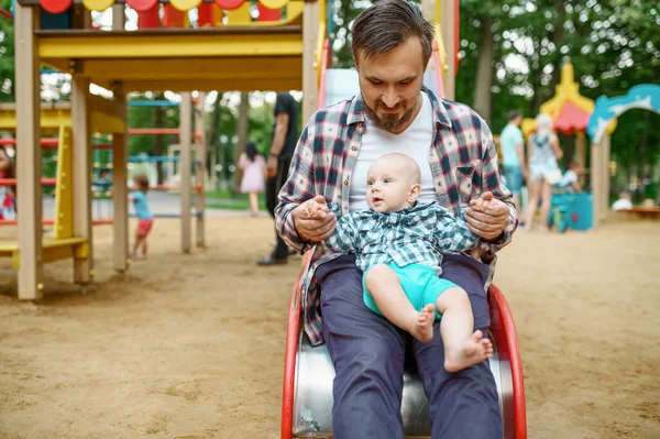 Счастливые родители играют с малышом на детской площадке — стоковое фото