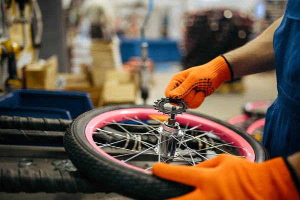 自転車工場 労働者は自転車の車輪に星を設定します 制服を着た男性の機械工は サイクル部品 ワークショップでの組立ライン 工業製造をインストールします — ストック写真