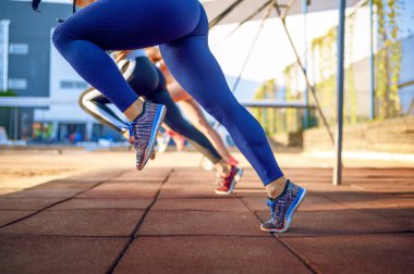 Spor alanında egzersiz yapan sporcu kadınlar, arka manzara, dışarıda grup fitness antrenmanı. Sıska bayan sporcular spor giyim, takım çalışması, takım çalışması.