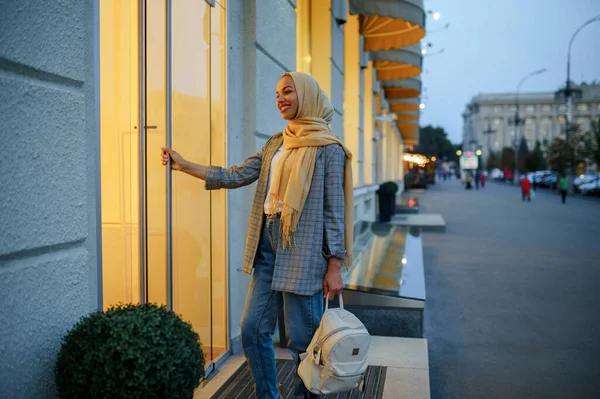 ダウンタウンのファッション店の入り口にヒジャーブのアラブの女の子 ムスリム女性が通りを歩いている 大都市の女子学生 宗教と教育 — ストック写真