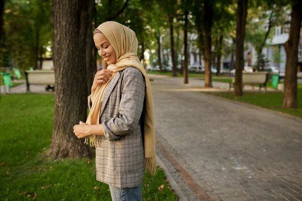 夏の公園でヒジャーブポーズの魅力的なアラブの女の子 イスラム教徒の女性は大学のキャンパスの芝生の上で休んでいます 宗教と教育 — ストック写真