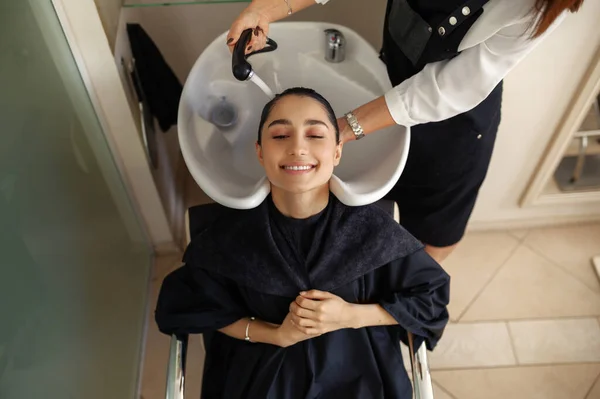 理发师洗头女人的头发 顶部视图 美发厅 理发店的发型师和客户美容业 专业服务 — 图库照片
