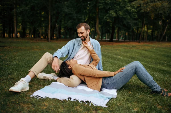 笑顔の愛のカップルは 芝生の上で トップビュー 公園内のロマンチックな散歩に休んでいる 男と女が毛布に寝そべっている 家族は夏の牧草地でリラックスし 週末は自然の中で — ストック写真