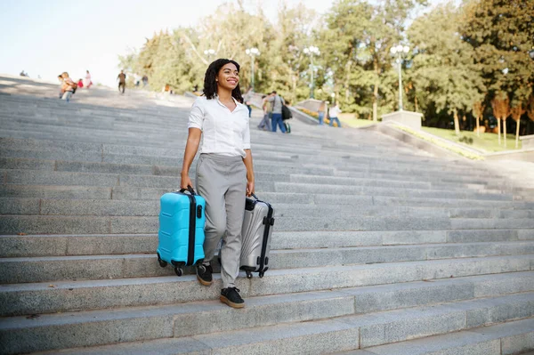 在夏季公园的楼梯上 女人提着两个手提箱 携带行李的女旅客在户外休息 携带行李的旅客在大自然中休息 带着行李的女孩在市区小巷里休息 — 图库照片