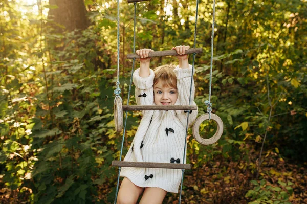 Mała Dziewczynka Wspina Się Drabinie Linowej Ogrodzie Kobieta Pozuje Podwórku — Zdjęcie stockowe