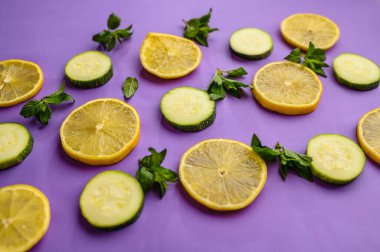 Mor arka planda taze limon ve salatalık dilimleri. Organik vejetaryen yiyecekler, market çeşitleri, doğal eko ürünler, sağlıklı yaşam tarzı konsepti.