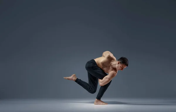 Mannelijke Yoga Houdt Balanc Een Moeilijke Houding Grijze Achtergrond Sterke — Stockfoto