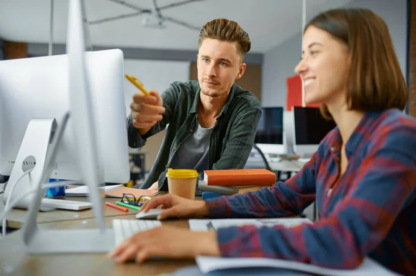 Two IT specialists works on computers in office