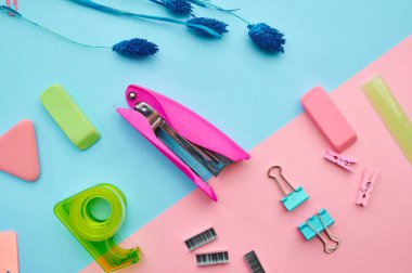 Zımba ve raptiyeler yakın plan, mavi arka plan. Ofis kırtasiye malzemeleri, okul veya eğitim aksesuarları, yazı ve çizim araçları