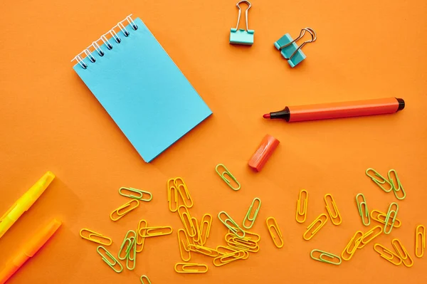 在橙色背景下的纸夹 笔记本和标识特写 办公用品 学校或教育配件 书写和绘图工具 — 图库照片