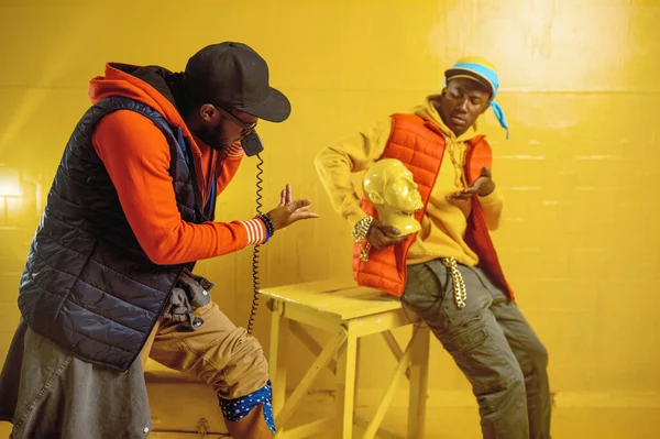 Rappers elegantes posa em estúdio, fundo amarelo — Fotografia de Stock