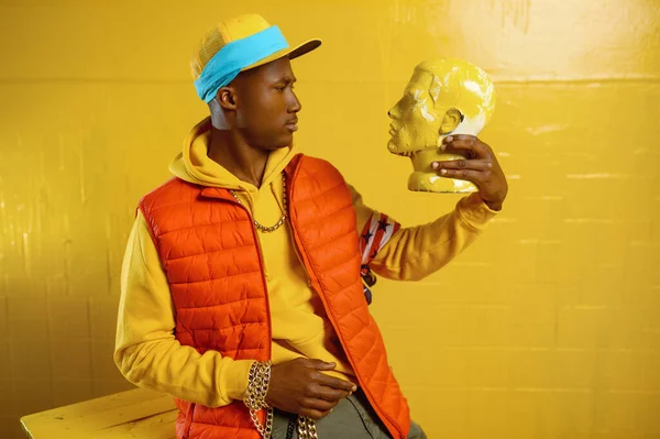Stijlvolle rapper poseert in studio met gele tinten — Stockfoto