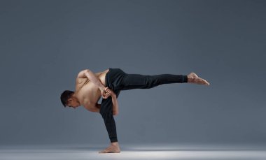 Yoga tek bacağında zor bir duruşta dengesini koruyor.