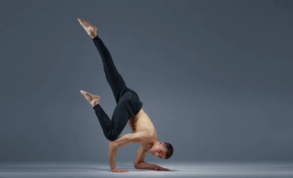 Mannelijke yoga houdt balanc in moeilijke houding op handen — Stockfoto