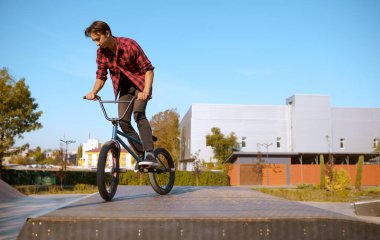 Bmx motorcusu hile yapıyor, genç kaykay pistinde