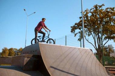 Bmx motorcusu hile yapıyor, genç kaykay pistinde