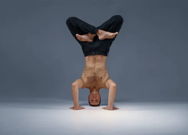 Mannelijke yoga staat op zijn hoofd, handen en benen — Stockfoto