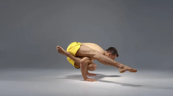 Yoga masculino em uma pose difícil nas mãos, meditação — Fotografia de Stock