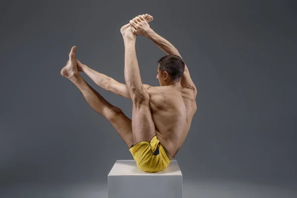 Mannelijke yoga zittend op de sokkel in studio — Stockfoto