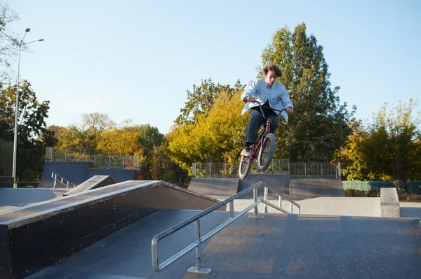Bmx骑自行车的人在滑板公园里靠栏杆搭车 — 图库照片