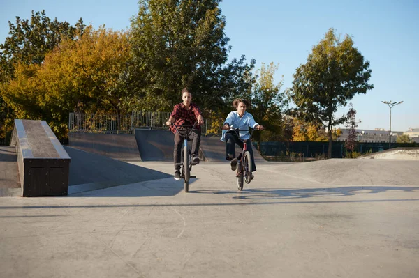 Young bmx bikers doing tricks in skatepark