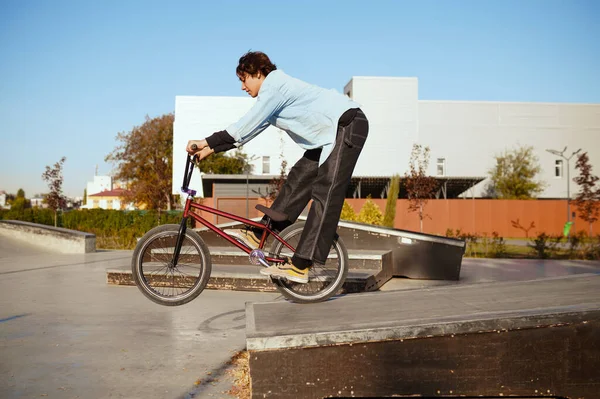 스케이트 공원에서 트릭을 하고 훈련받고 있는 어린 bmx 자전거 선수 — 스톡 사진