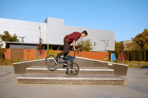 Bmx motociclista fazendo truque em escadas no skatepark — Fotografia de Stock