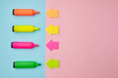 Açık renkli keçeli kalemler ve manyetik oklar. Ofis kırtasiye malzemeleri, okul veya eğitim aksesuarları, yazı ve çizim araçları