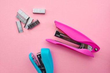 Zımba yakın plan, pembe arka plan. Ofis kırtasiye malzemeleri, okul ya da eğitim araçları