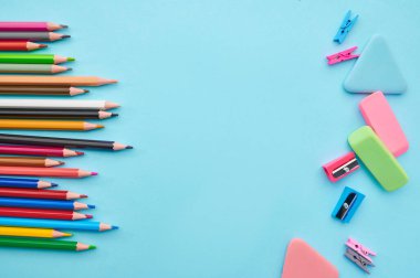 Mavi arka planda renkli kalemler ve prezervatifler. Ofis kırtasiye malzemeleri, okul veya eğitim aksesuarları, yazı ve çizim araçları