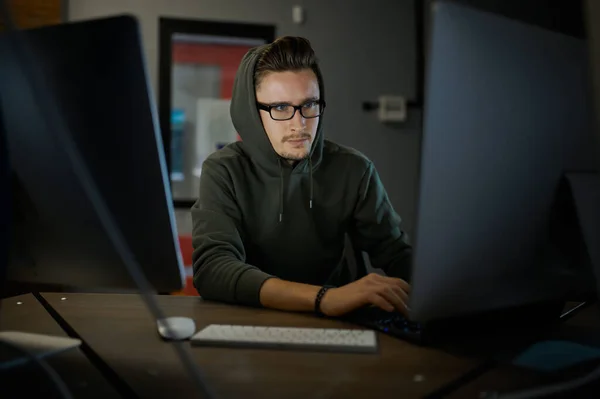 Man Internet Hacker Huva Och Glasögon Sitter Monitorer Olaglig Webbprogrammerare — Stockfoto