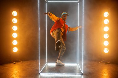 Aydınlatılmış küpüyle sahnede şık bir rapçi. Hip-hop sanatçısı, rap şarkıcısı, break dans performansı, eğlence yaşam tarzı