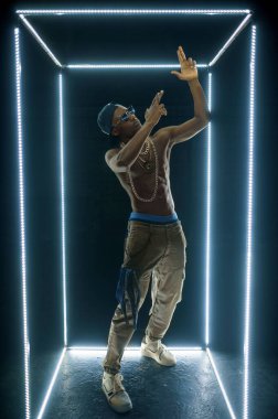 Altın zincirli, alt görüşlü, esmer bir rap şarkıcısı. Hip-hop sanatçısı, rap şarkıcısı, break dans performansı, eğlence yaşam tarzı, break dans