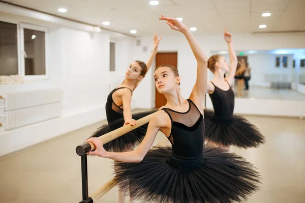 Drie jonge ballerina 's, tieners repeteren op de barre — Stockfoto