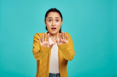 Korkmuş kadın portresi, mavi arka plan, duygu. Yüz ifadesi, stüdyoda kameraya bakan kadın, duygusal konsept, duygular.