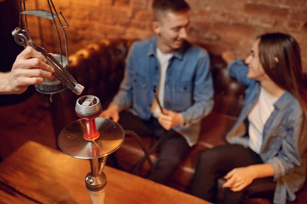 Love couple relax in hookah bar, hooka smoke. Shisha smoking, traditional bong culture, tobacco aroma for relaxation, rest with hooka