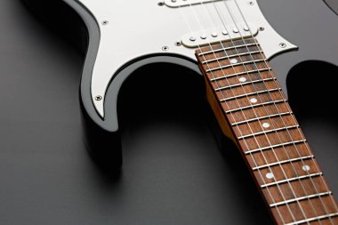 Elektro gitar yakın plan, siyah arka plan, kimse yok. Telli müzik aleti, elektro ses, elektronik müzik, sahne konseri için ekipman.