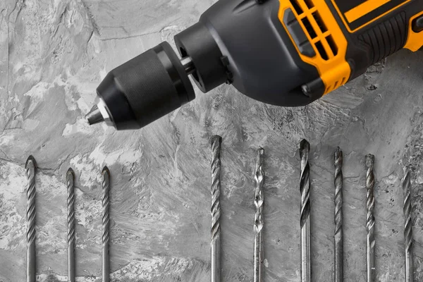 Set of borers and drill, concrete background — Stock Photo, Image