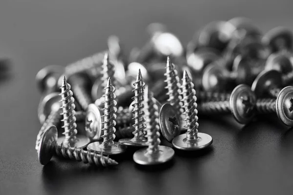 Stack of self-tapping screws, grey background — Stock Photo, Image