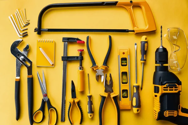 Workshop instrument, top view, yellow background — Stock Photo, Image