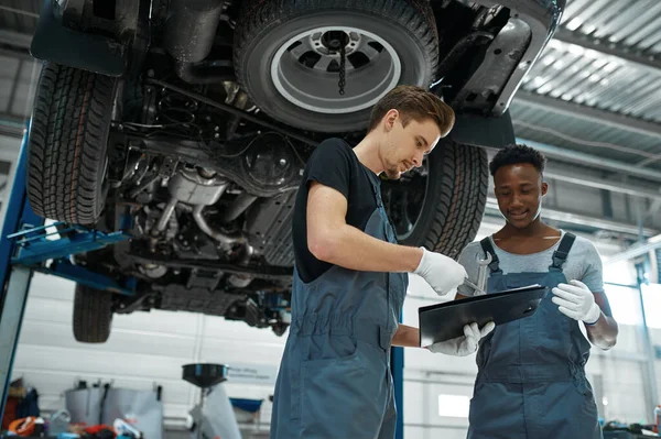 Two Male Mechanics Looking Checklist Car Service Vehicle Repairing Garage — Stock Photo, Image