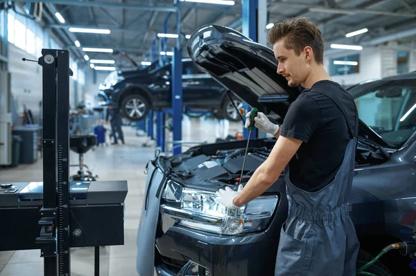 Mężczyzna Mechanik Dostosowuje Reflektory Serwis Samochodowy Warsztat Samochodowy Człowiek Mundurze — Zdjęcie stockowe