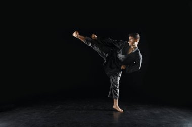 Erkek karateka, siyah kimonolu dövüşçü, savaş duruşu, karanlık bir geçmişi var. Antrenman yapan adam, dövüş sanatları, dövüş öncesi antrenman
