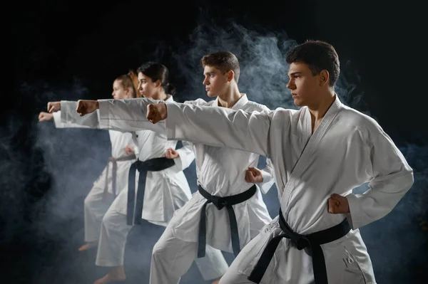 Vier Karate Vechters Poseren Witte Kimono Groepstraining Donkere Rokerige Achtergrond — Stockfoto