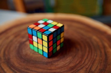 Tahta kütükte klasik renkli yapboz küpü, yakın çekim görüntüsü, kimse yok. Beyin ve mantıksal zihin eğitimi için oyun, yaratıcı oyun, karmaşık problemlerin çözümü