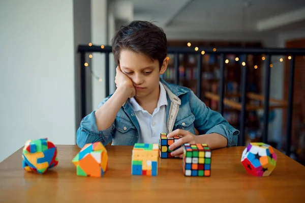 Rapazinho Olha Para Cubos Quebra Cabeças Brinquedo Para Cérebro Treinamento — Fotografia de Stock