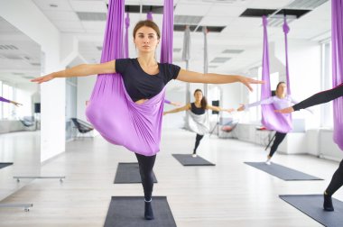 Yer çekimi yogasında uçmak, hamaklı kadın grubu eğitimi. Fitness, pilates ve dans egzersizleri karışımı. Yoga yapan kadınlar