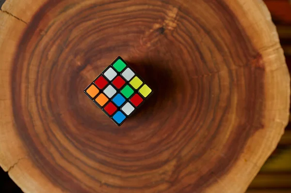 木制树桩上经典的彩色拼图立方体 特写镜头 智力和逻辑思维训练 创意游戏 解决复杂问题的玩具 — 图库照片