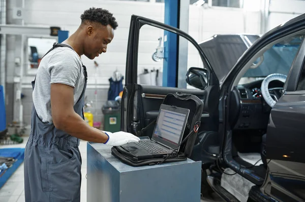 Mężczyzna Mechanik Pomocą Laptopa Samochodzie Otwartym Kapturem Serwis Samochodowy Warsztat — Zdjęcie stockowe