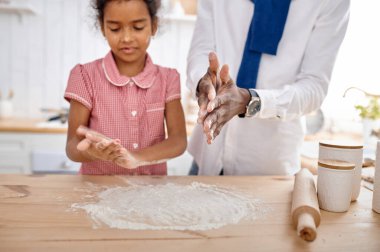 Mutlu baba-kız kahvaltıda kek pişiriyor. Gülümseyen aile sabahları mutfakta yemek yer. Babası kadın çocuğu besliyor, iyi bir ilişki.